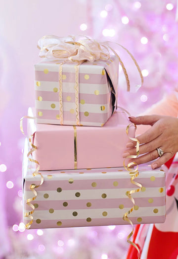  Eine Frau trägt drei große Geschenkpackungen