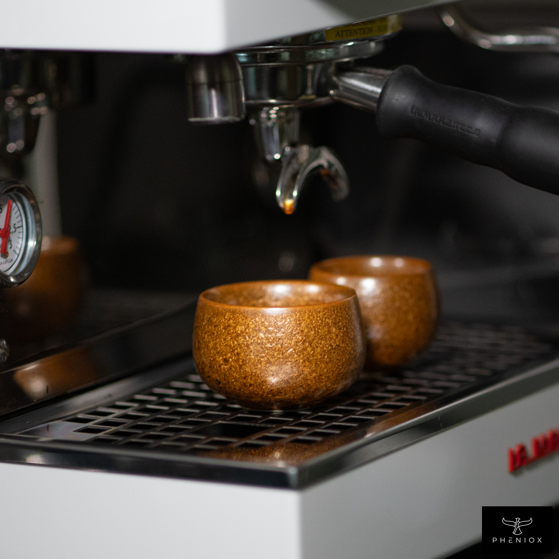 Zwei verschieden Große braune Espressotassen stehen nebeneinander auf einer Siebträgermaschine zum Größenvergleich