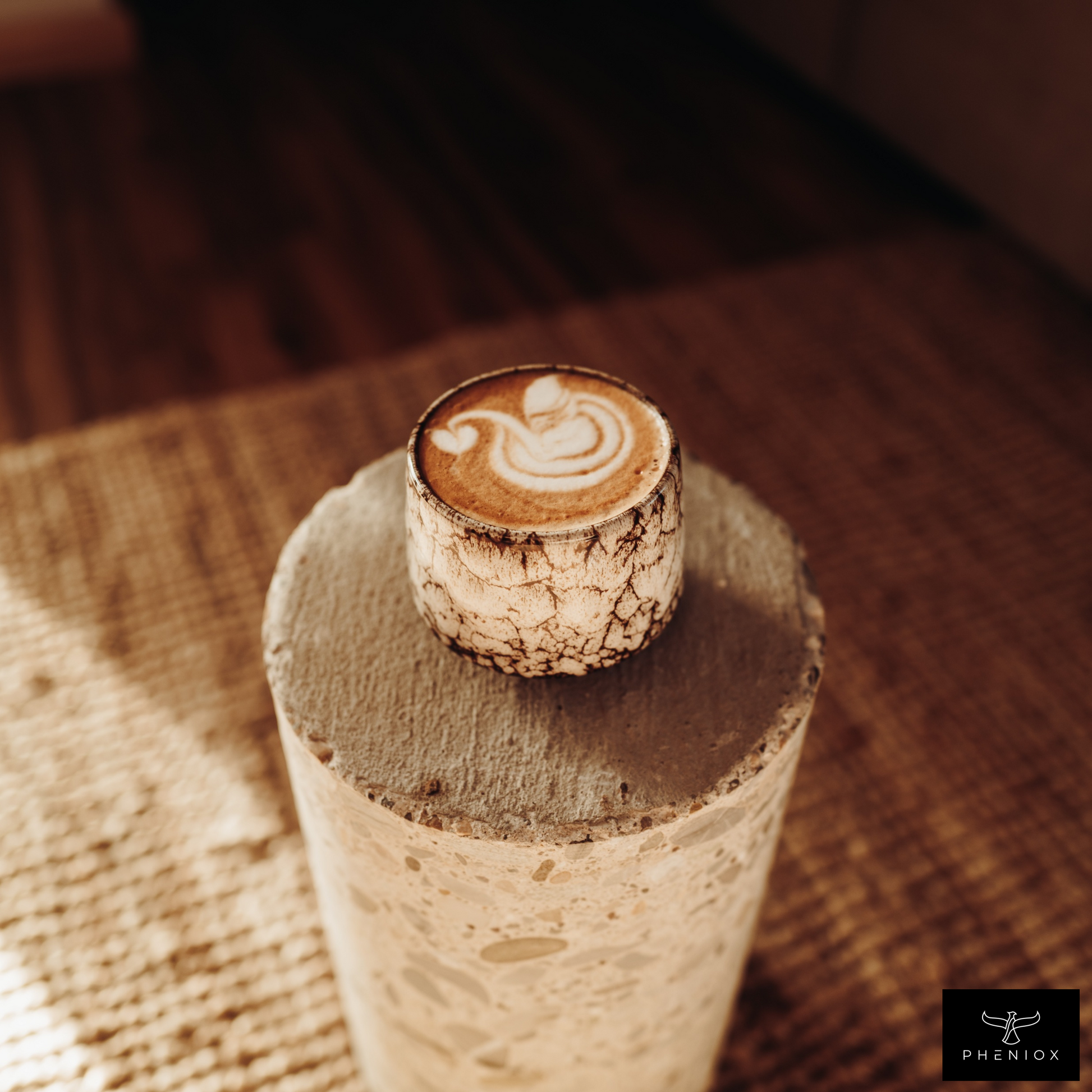 Weiße Cappuccino Tasse mit Schwanen Latte Art steht auf Betonblock in Wohnzimmer